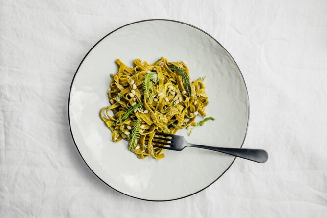 Kurkuma-Bandnudeln mit Schafgarben-Zitronen-Pesto | © SONNENTOR Auf dem Foto sieht man einen Teller mit Kurkuma-Bandnudeln. | © SONNENTOR